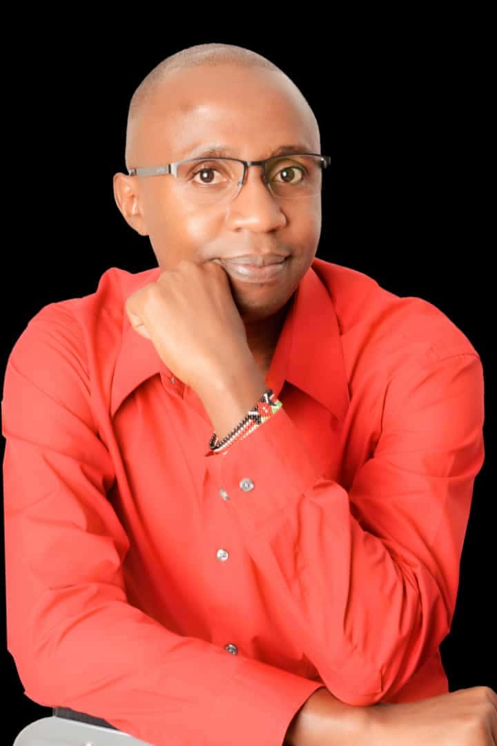 Kelvin Mwangi Kamau in red shirt – thoughtful pose
